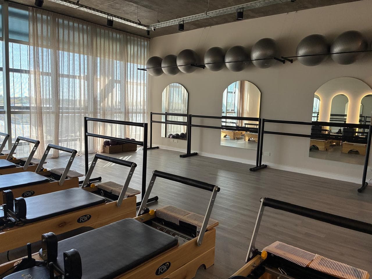 Vista general de la sala, con la barra y las pelotas de pilates